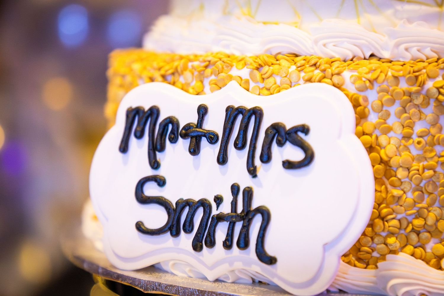 Wedding cake sign reading Mr and Mrs Smith with gold decorative details.
