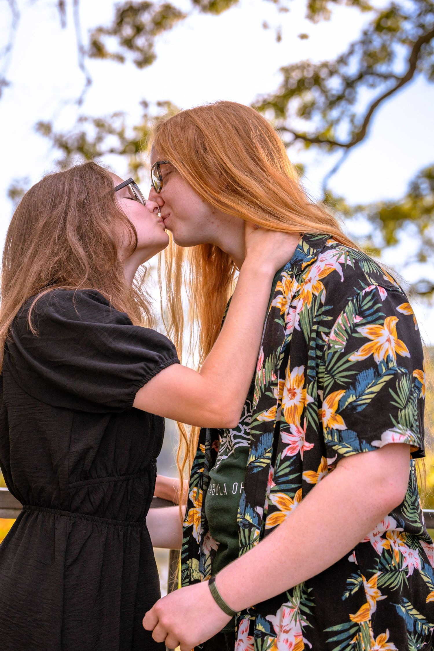 Two people sharing an intimate moment outdoors in floral and black clothing.
