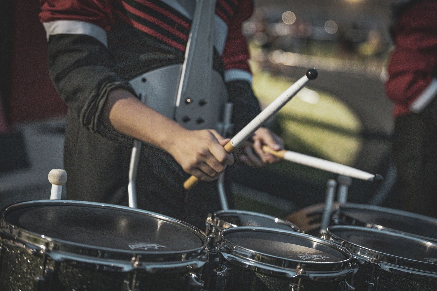 Drumsticks in motion over a drum set during a musical performance.
