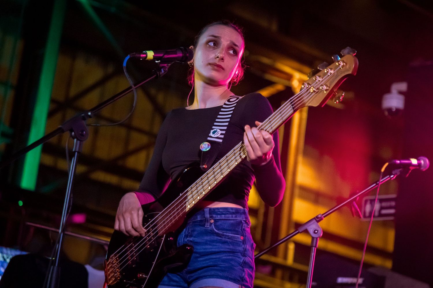 Musicians performing on stage with colorful lighting and instruments at a live concert venue.