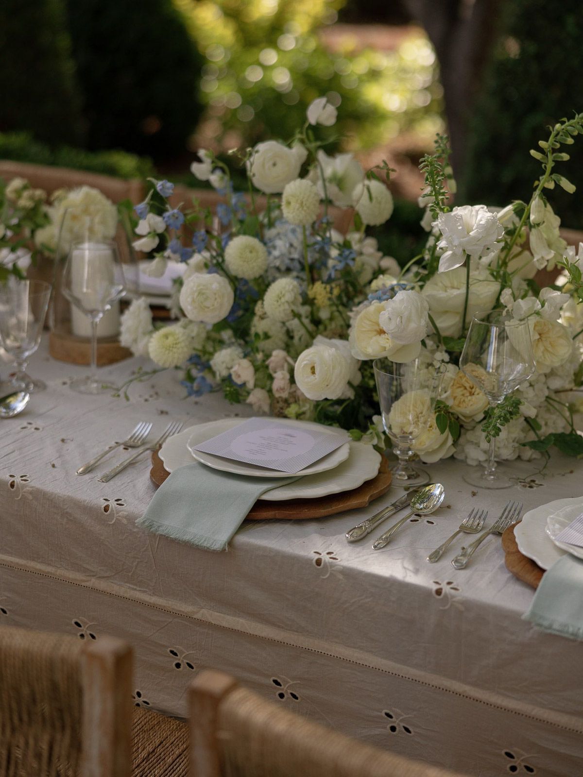 Elegant wedding table setting with white roses and delicate place settings.