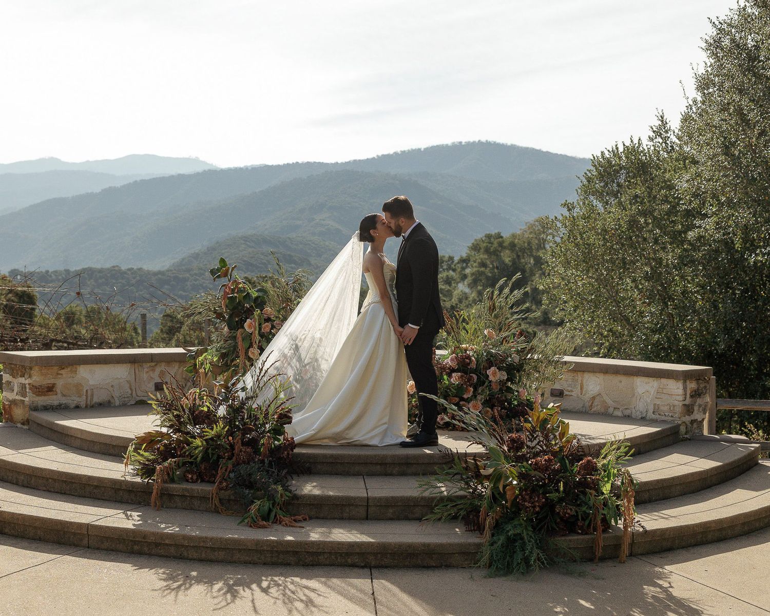 Wedding ceremony photography of a bride and groom kissing during their ceremony at Holman Ranch.