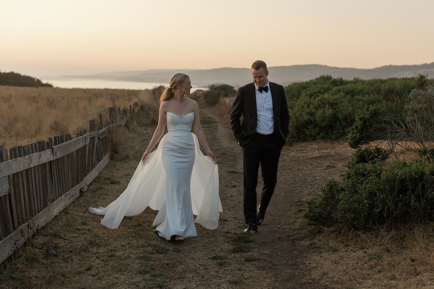 Bride and groom walking together during sunset portraits at Sea Ranch Lodge in Sea Ranch, California.