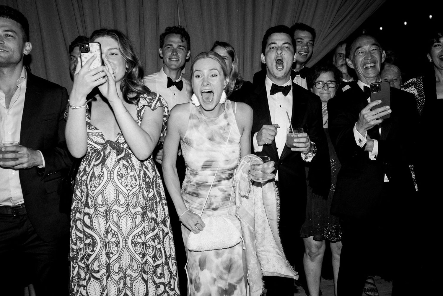 Wedding guests at Holman Ranch in formal attire celebrating and reacting with joy at a reception.
