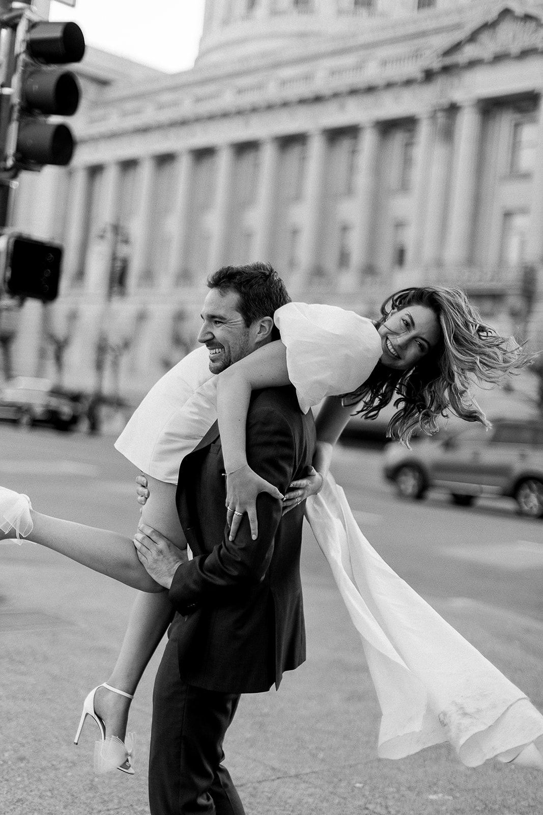 A romantic dance dip pose captured in black and white on a city streets of San Francisco City Hall.