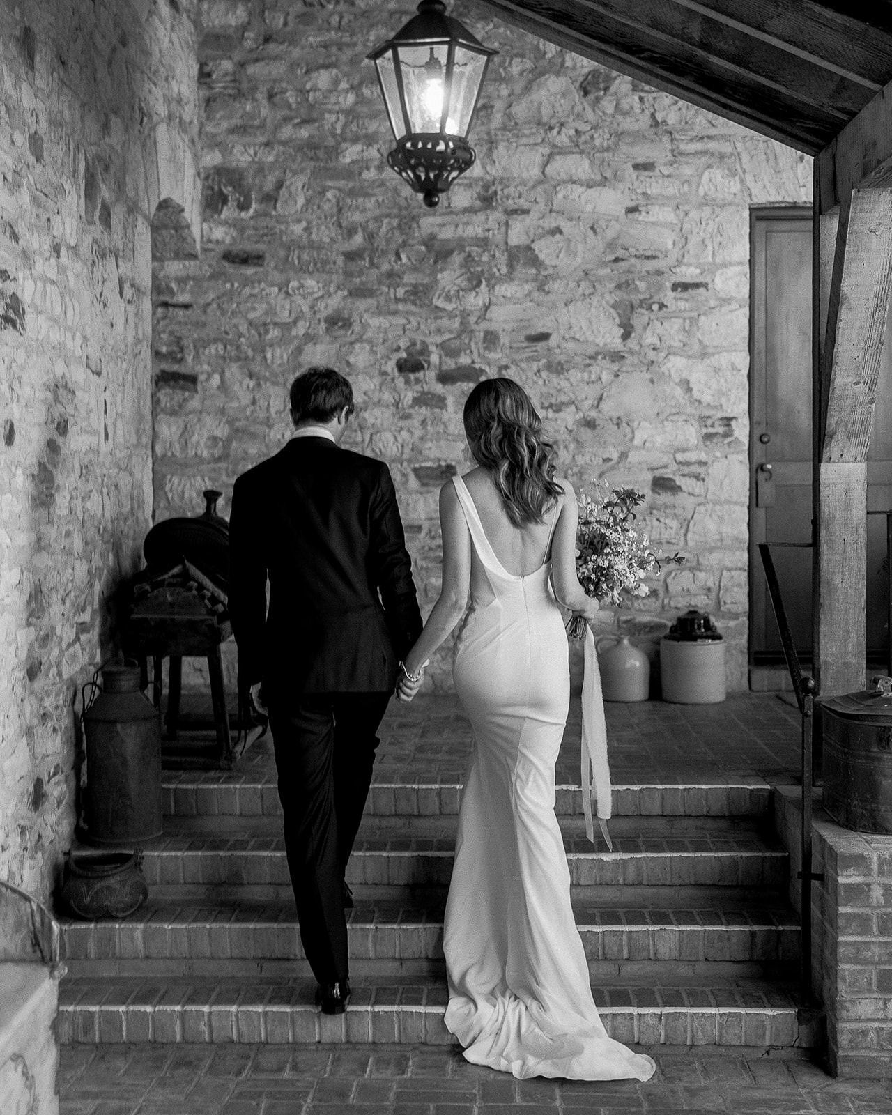 Wedding photography of a coupe walking through the courtyard at Holman Ranch in Carmel Valley, California.
