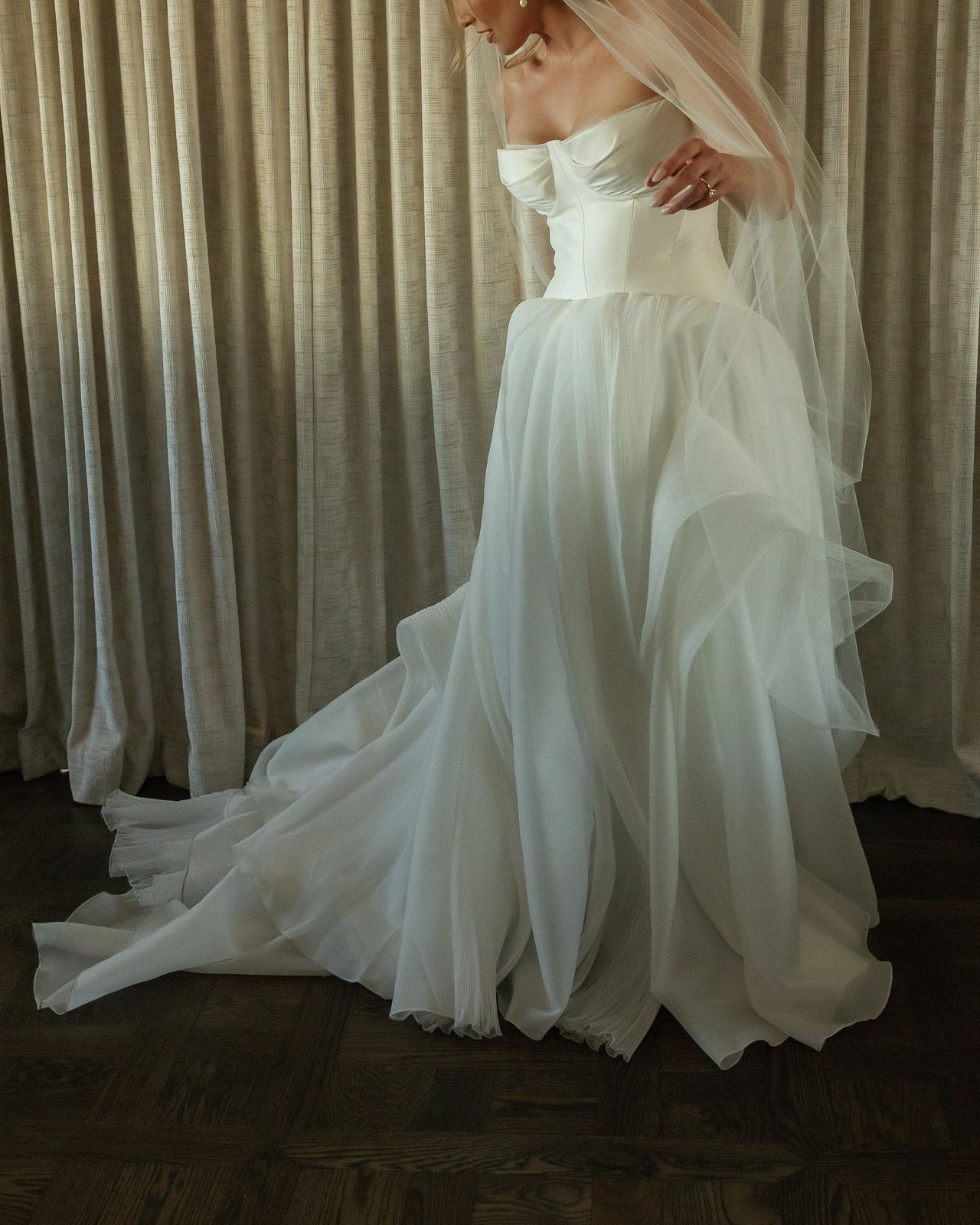 A flowing white wedding gown with delicate layers and a sweetheart neckline.