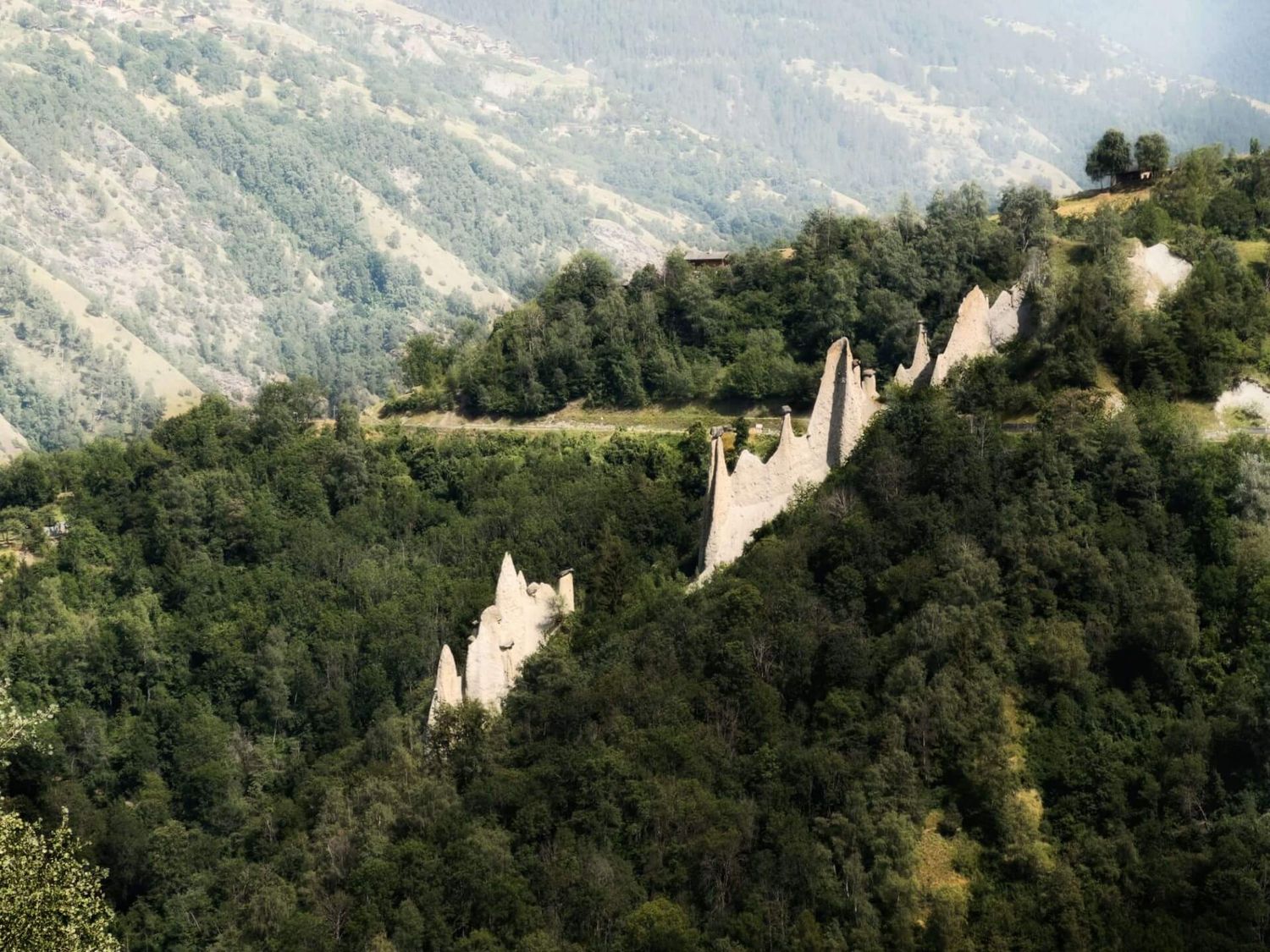 Mit dichtem Wald bedeckte Felsformationen aus aufgeschichtetem Lehm von einem Aussichtspunkt aus gesehen.
