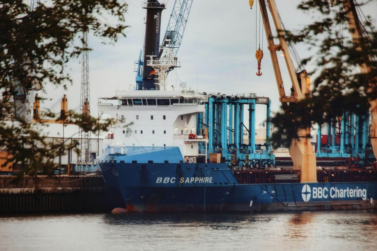 Das blaue Frachtschiff BBC Sapphire angedockt im Industriehafen mit Ladekränen.