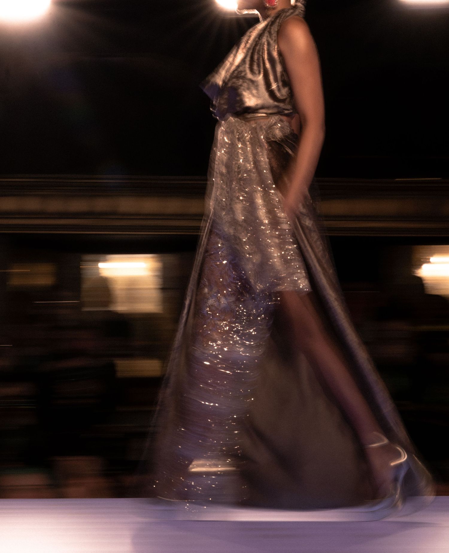 A glance of spark and bronze. Motion blur runway photography at Runway7 2025 NYWF.   © Jack Curtis Photography.