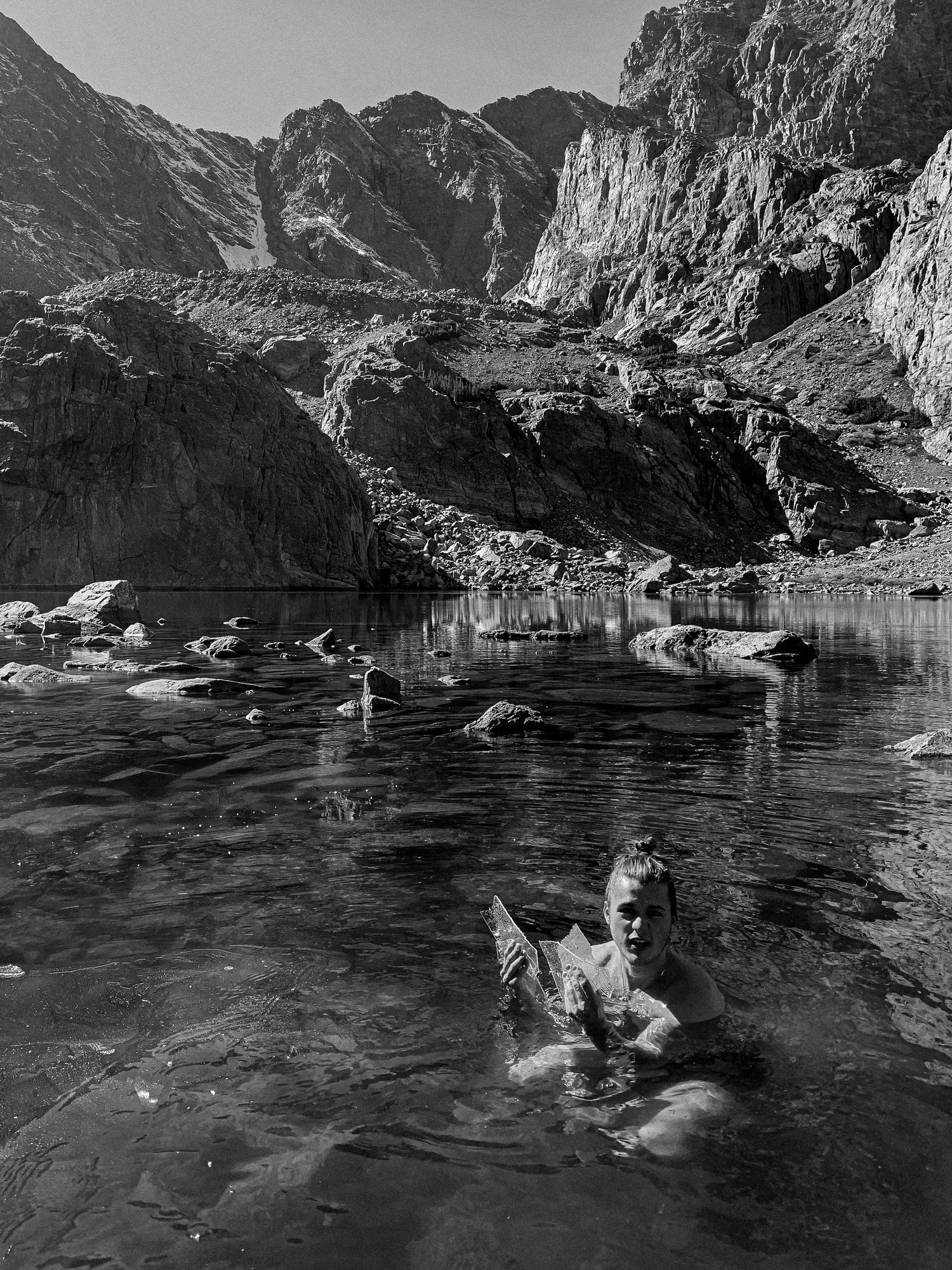 Man in a lake of glass. Chasm Lake. Rocky Mountain National Park during Spring 2023. © Jack Curtis Photography.