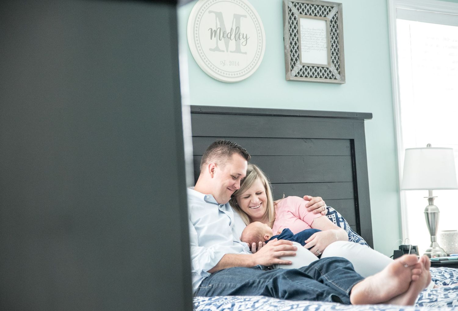 Couple relaxing at home with newborn baby near fireplace.