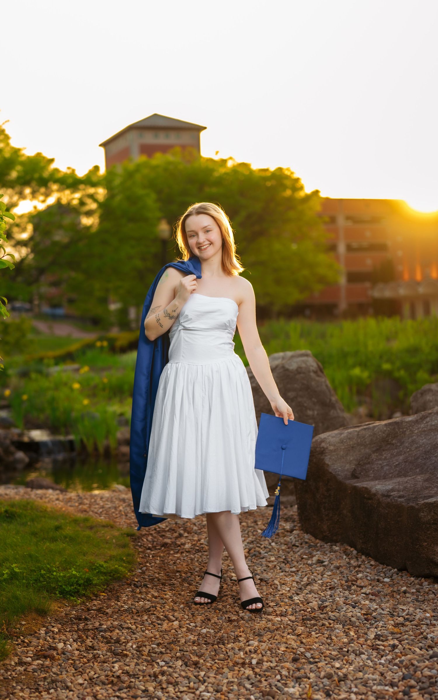 A romantic sunset photoshoot on rocky terrain with buildings in the background.