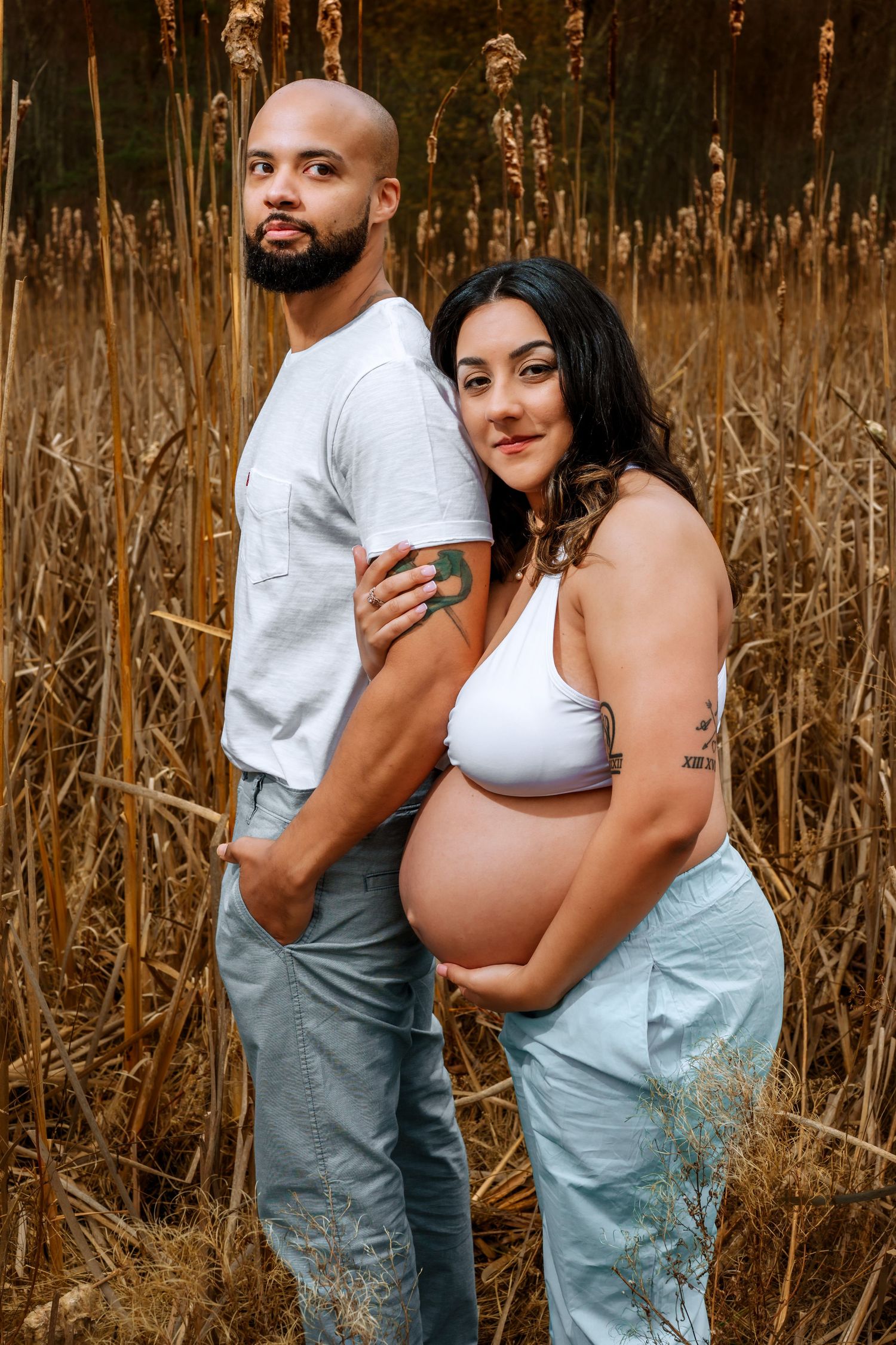 Intimate maternity photo sequence in a field of tall dried reeds at golden hour.