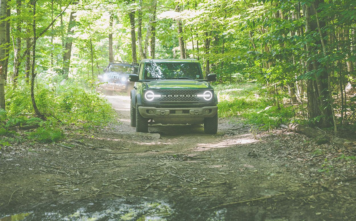 Ford Bronco off roading in woodland setting