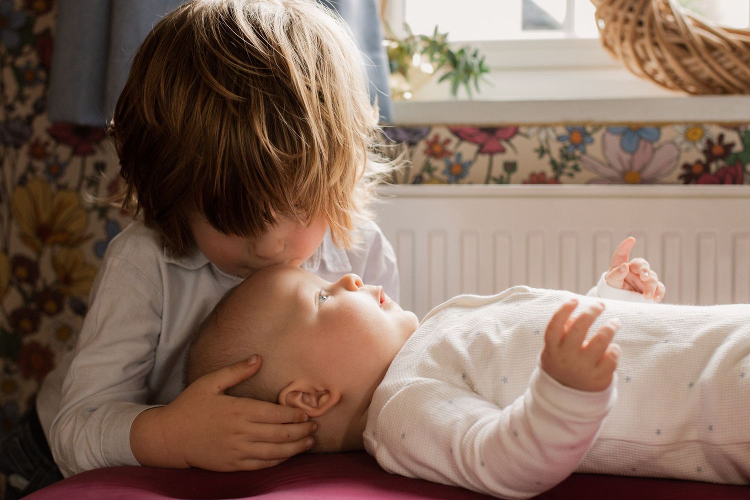 Intimate family moment captured in soft natural window light.