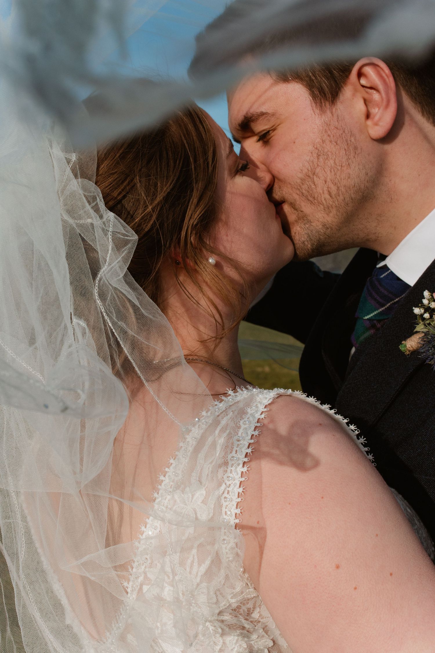 A romantic wedding couple shares an intimate kiss in a series of progressive close-up shots with a flowing veil.