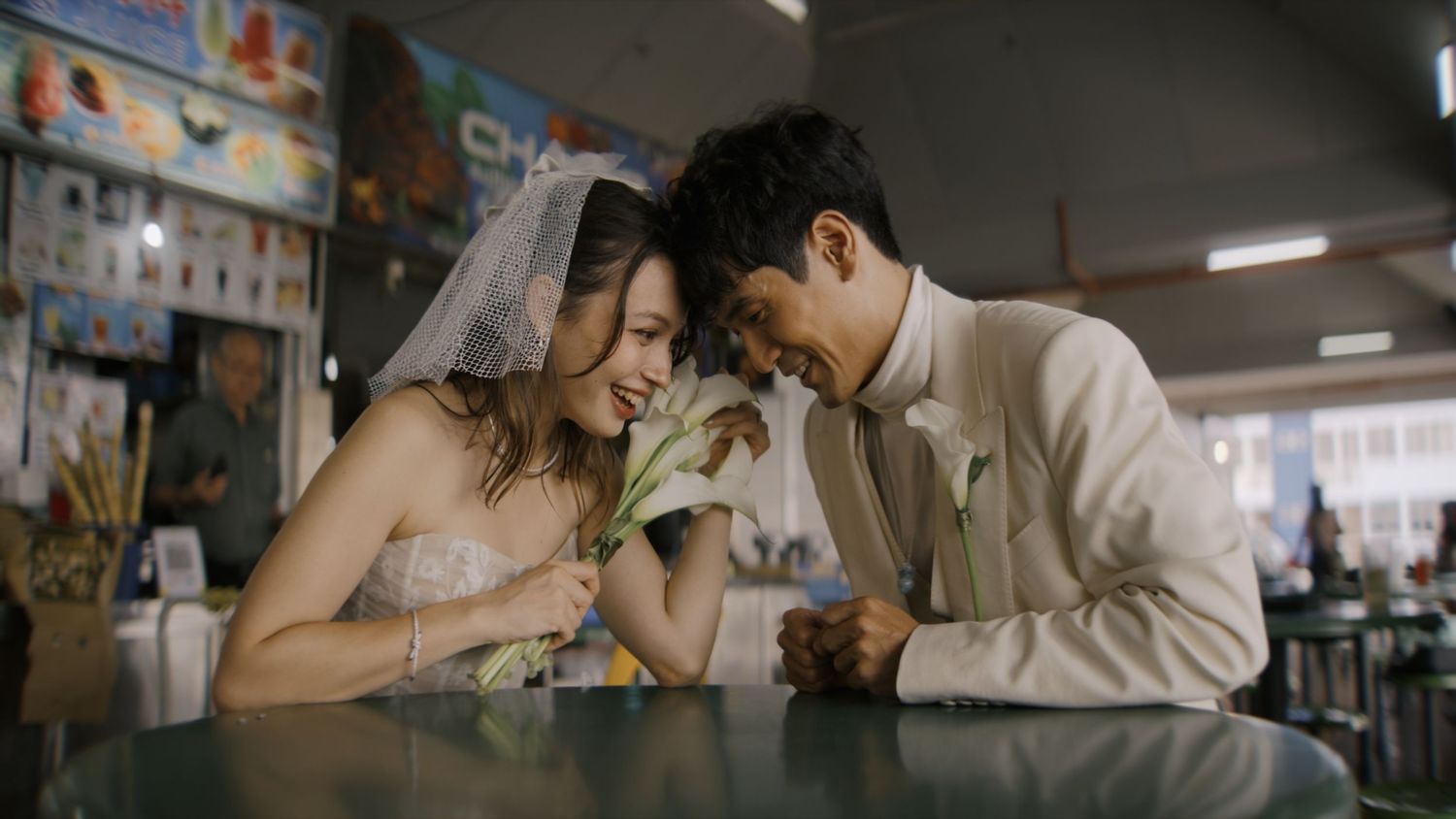 A couple shares an intimate moment in a romantic embrace while standing in a dimly lit room.