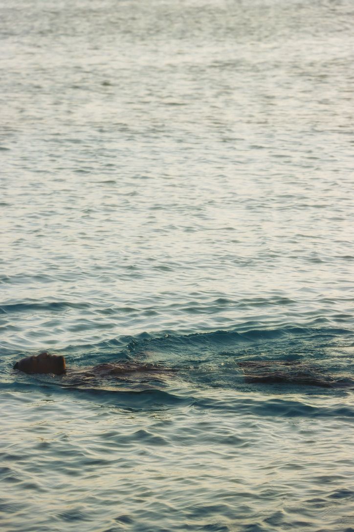 Calm ocean waves rippling across surface at sunset creating serene patterns. By Chrissie McLean Photography.