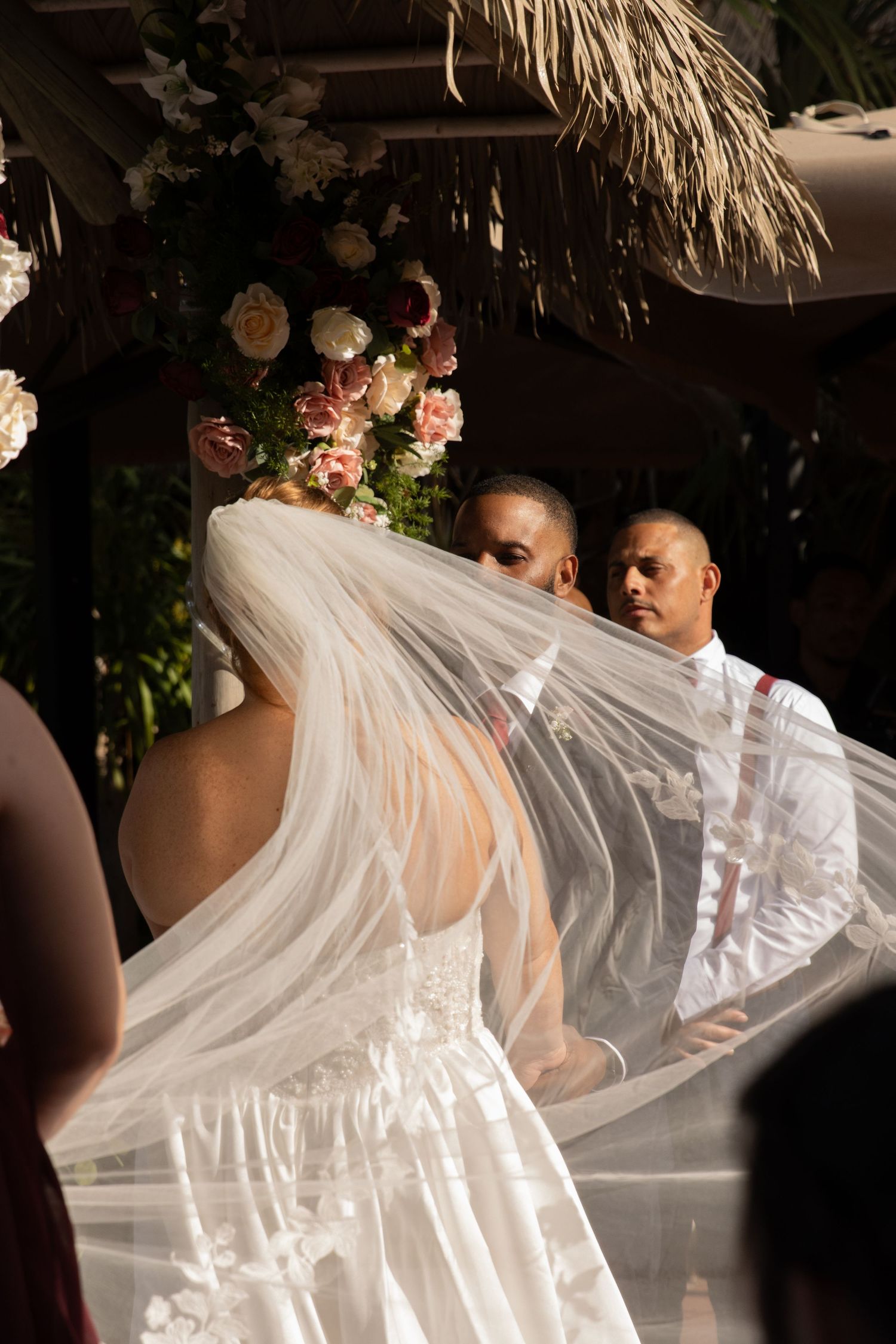 Wedding ceremony moment with flowing white veil movement in dramatic lighting. By Chrissie McLean Photography.