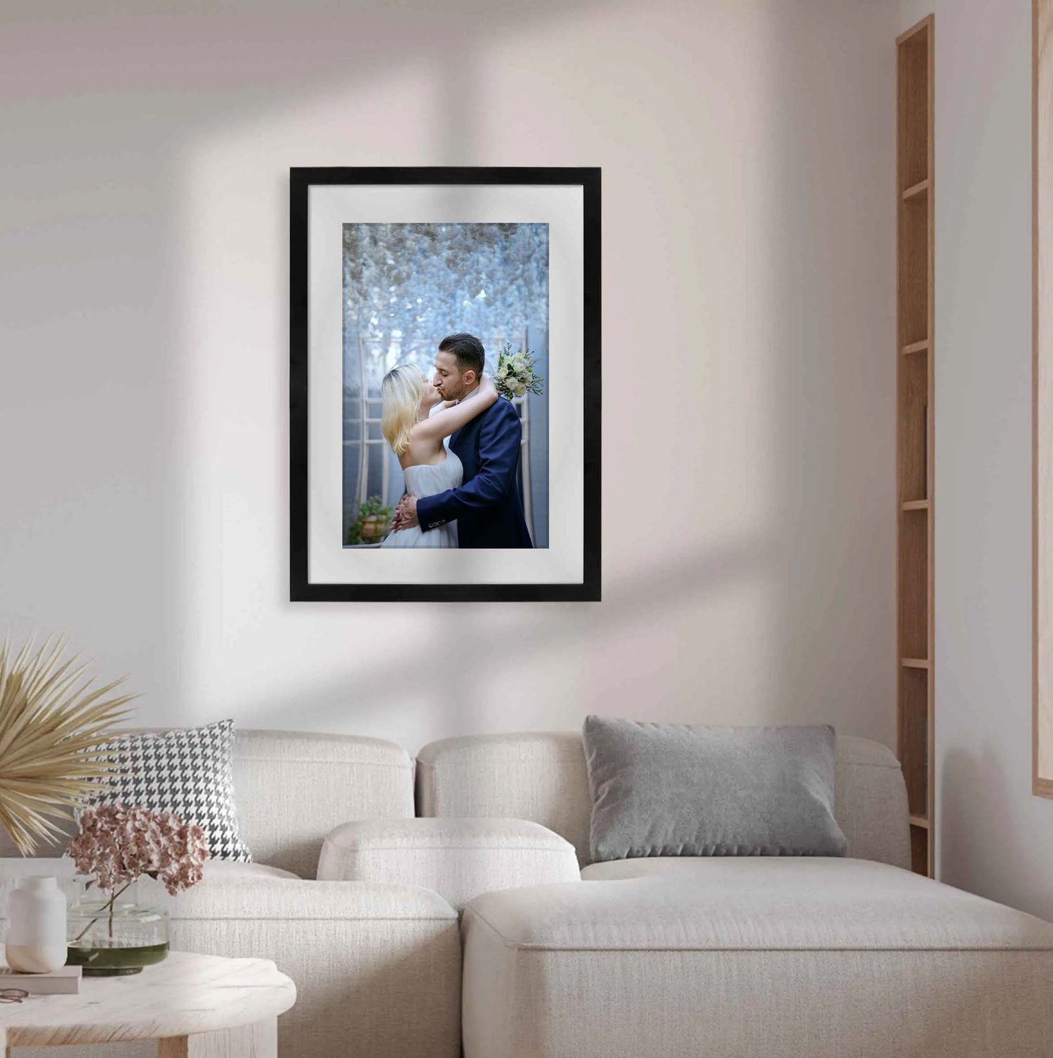 Interior de sala moderna con paredes blancas minimalistas, un cuadro de boda enmarcado, y una acogedora disposición de asientos.