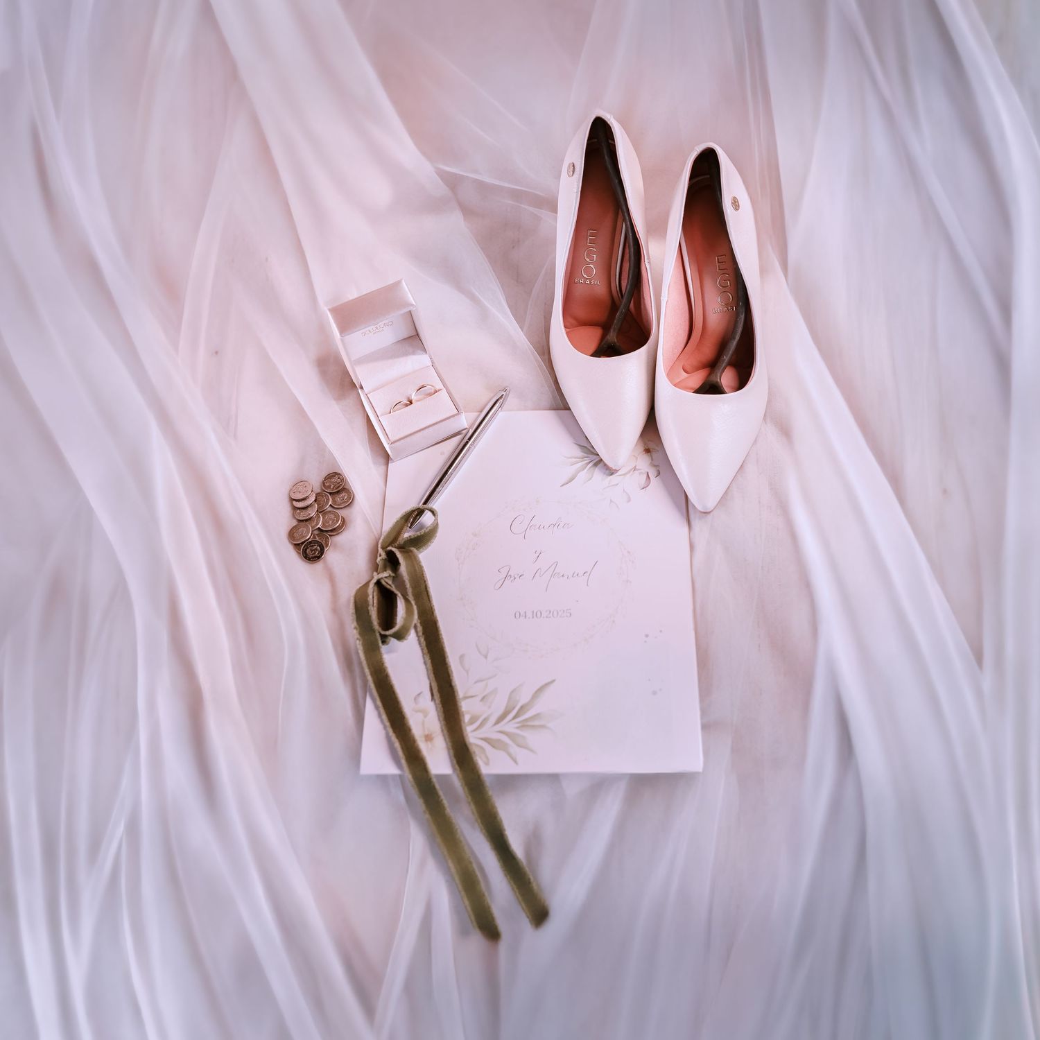 Llaves de latón vintage dispuestas sobre una tela blanca fluida, creando una elegante toma de detalle de boda.
