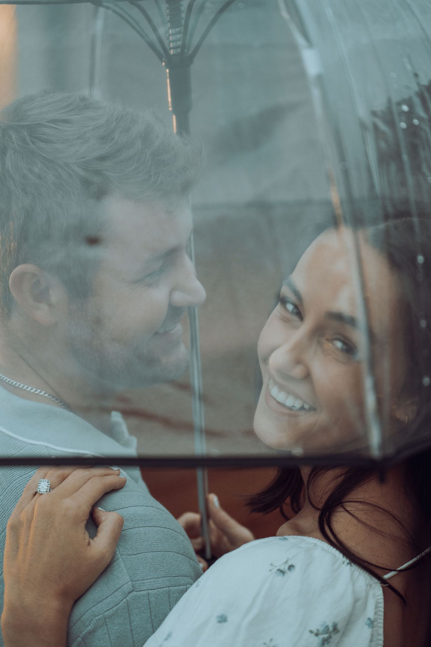 A romantic couple shares an intimate moment behind a foggy window on a rainy day.