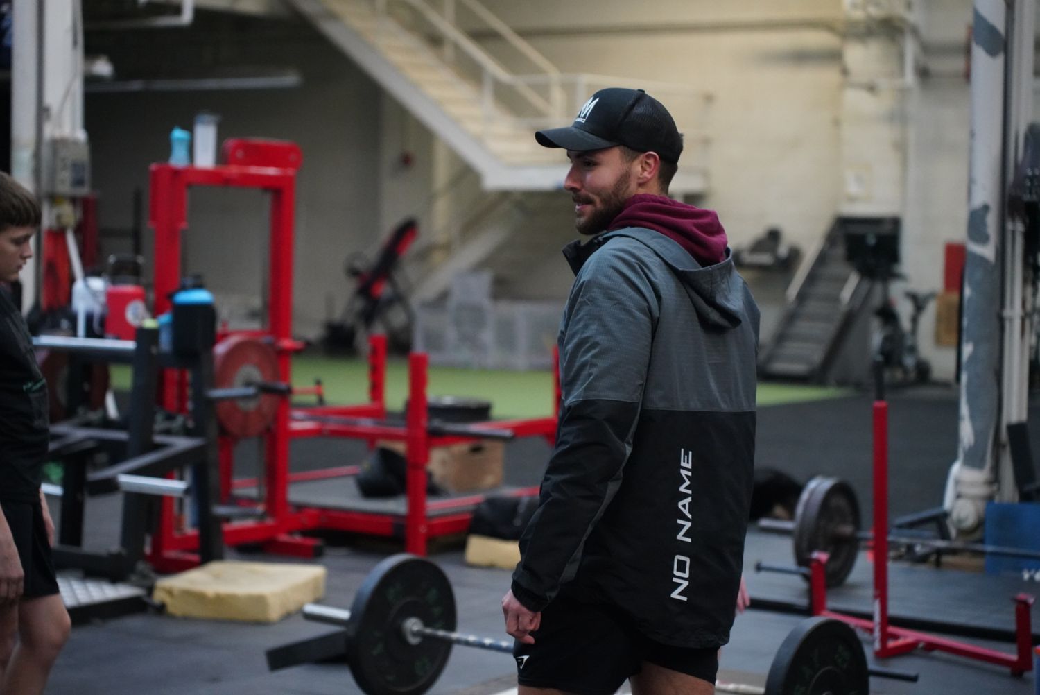People exercising with barbells and weights in a modern fitness facility.