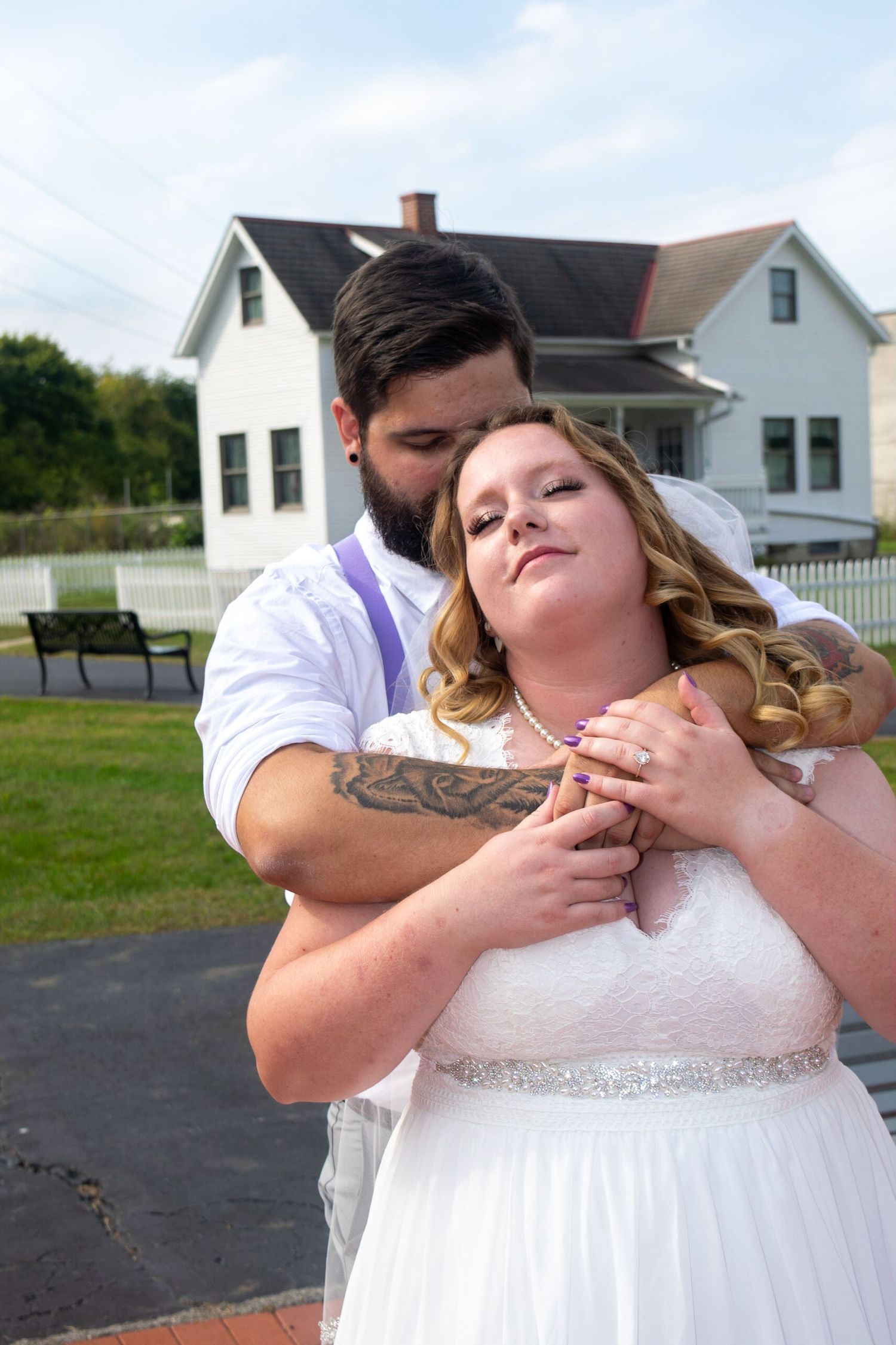 Intimate wedding portraits captured outside a white farmhouse with romantic poses.