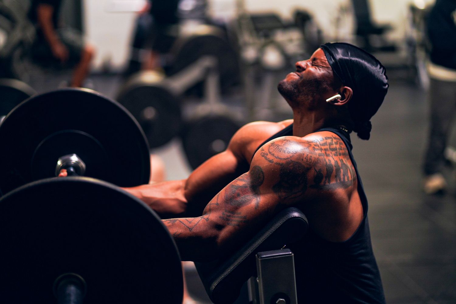 Athletes performing strength training exercises in a dark gym environment.