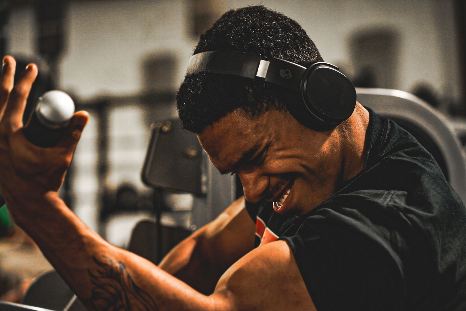 Person exercising in dark gym environment with dramatic lighting.