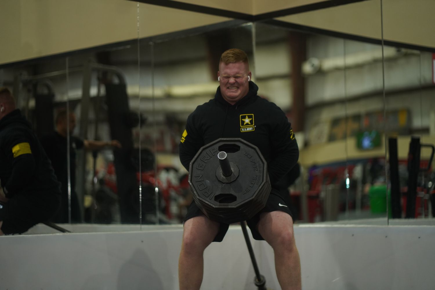 Fitness enthusiast performs exercises in a dimly lit gym setting.