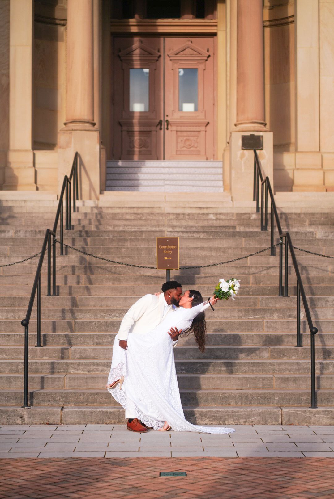 A romantic wedding photoshoot on historic stone steps of a building.