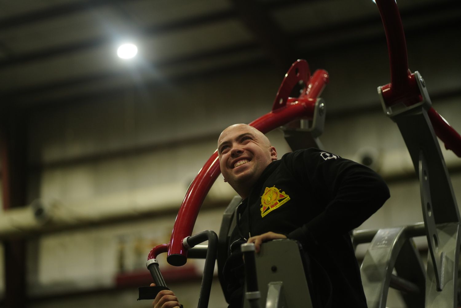 Weightlifting athlete in black attire performs an intense workout at a training facility.