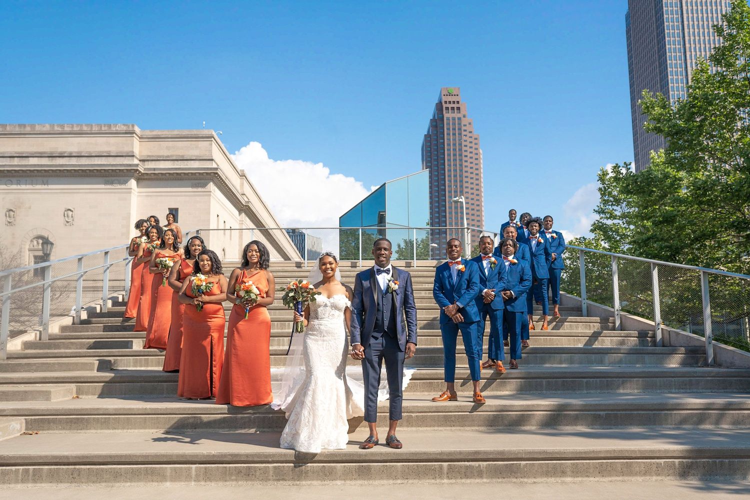 Wedding party poses with city skyline in background.