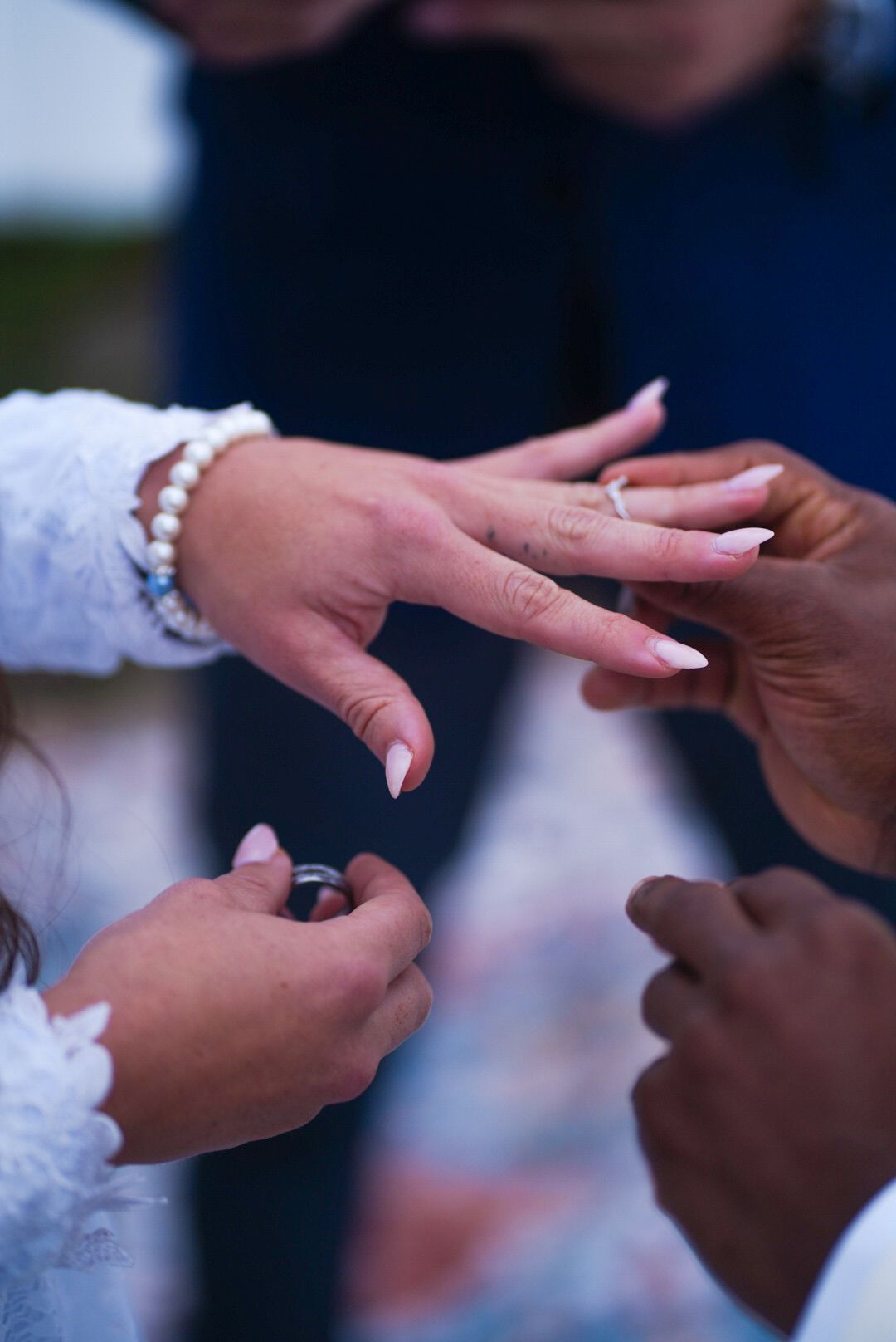 Detailed shot of wedding ring exchange between couple during ceremony.