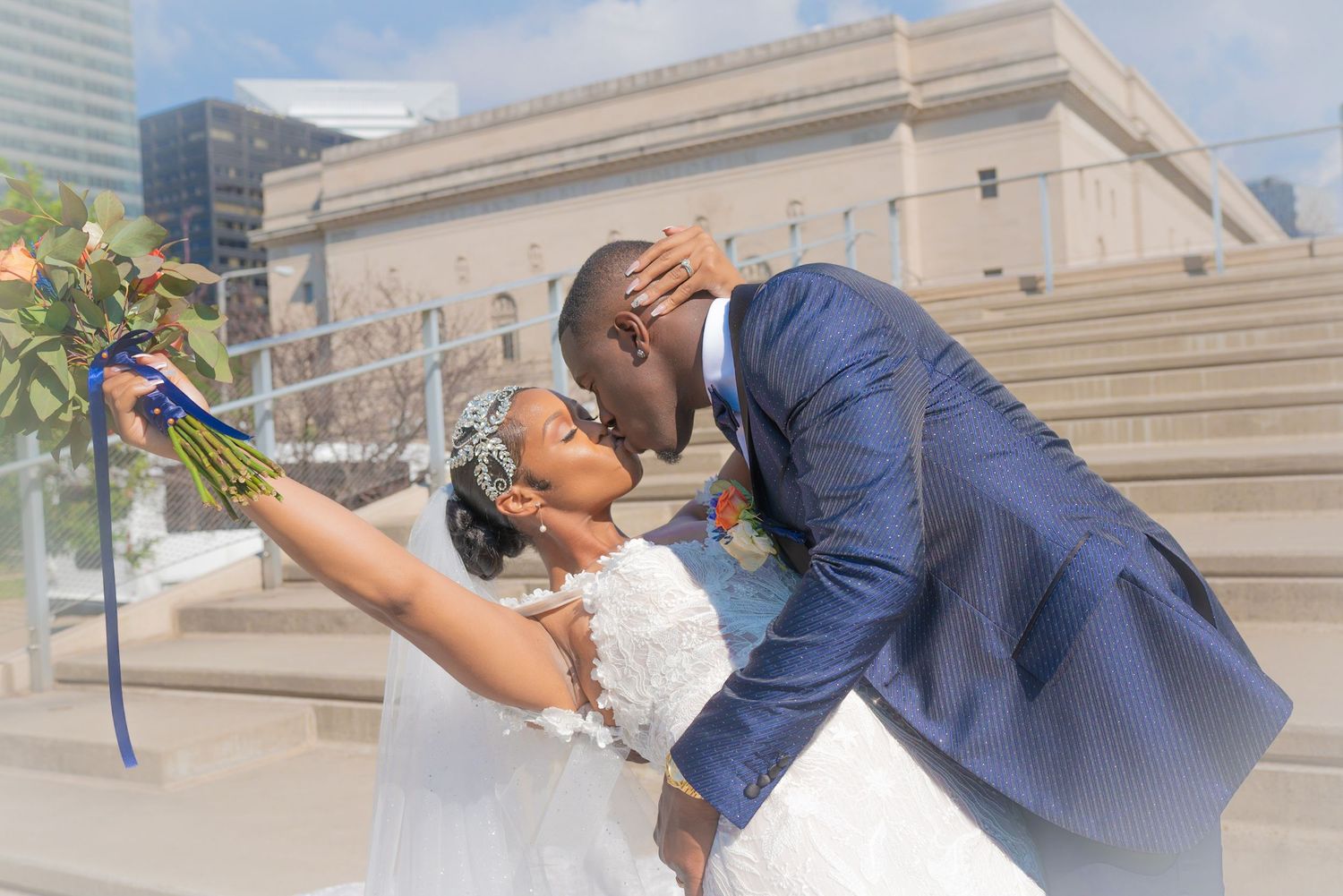 Wedding couple embracing against urban backdrop with modern buildings.