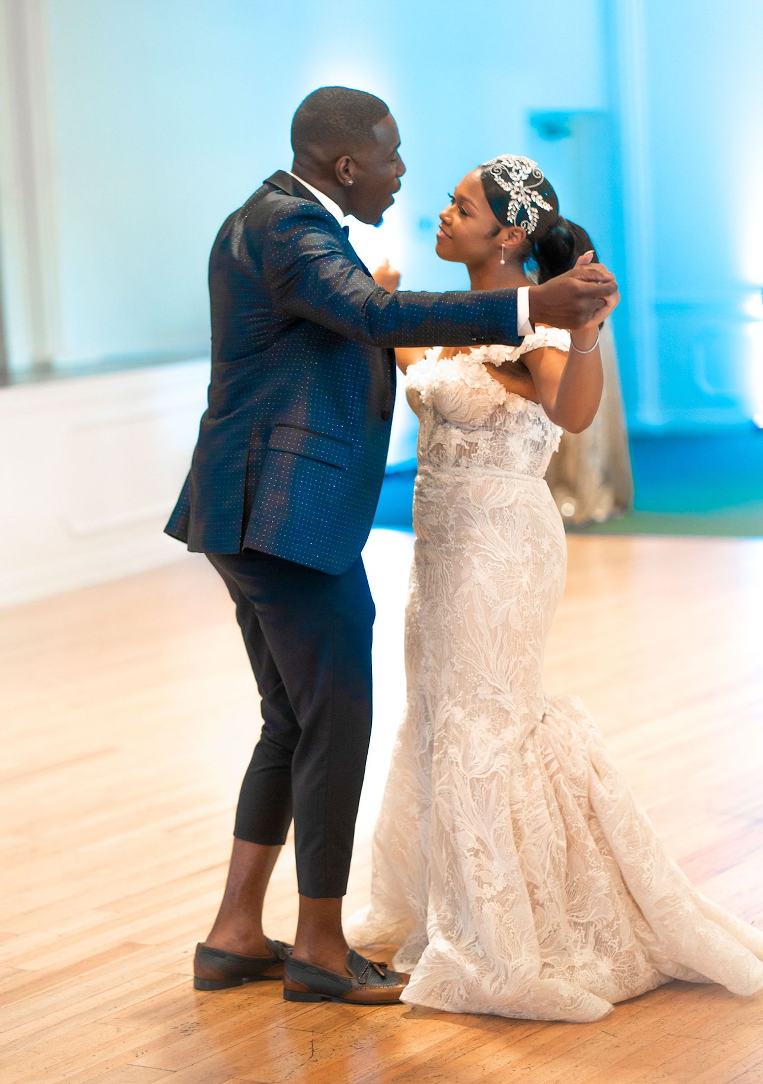 Wedding couple sharing an intimate first look moment in a bright indoor setting.
