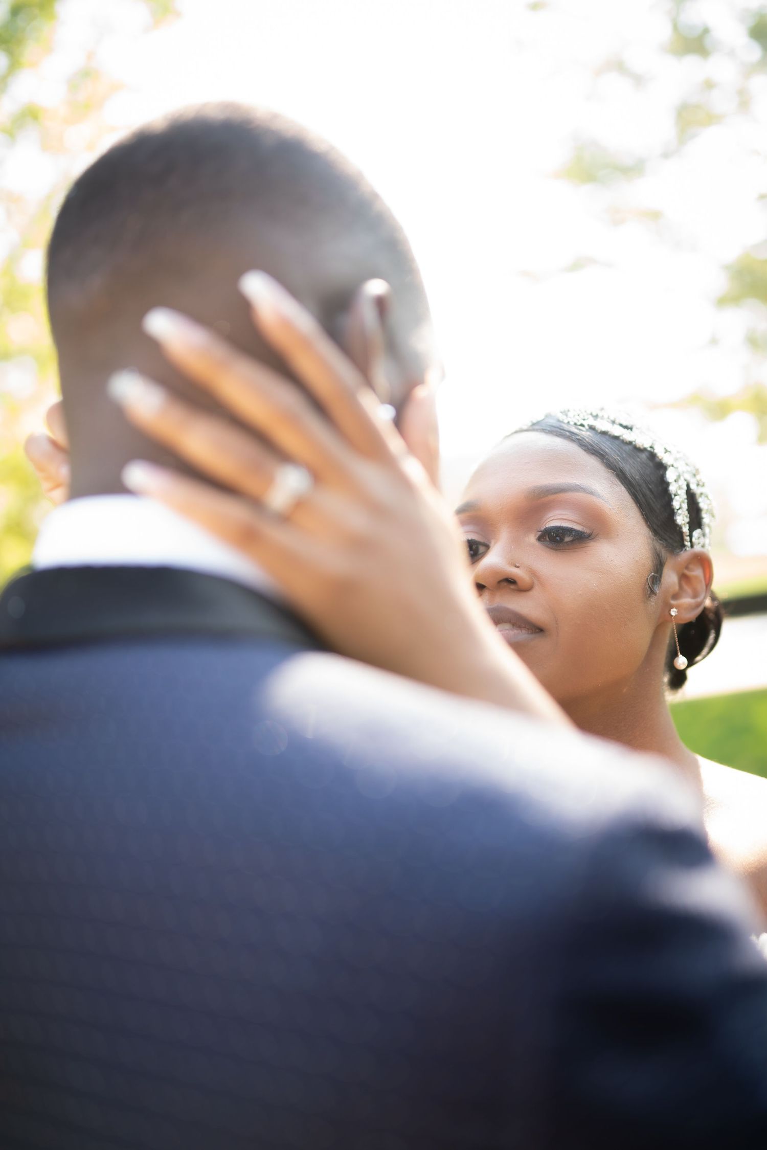 Close-up romantic moment between newlyweds during outdoor wedding photoshoot.