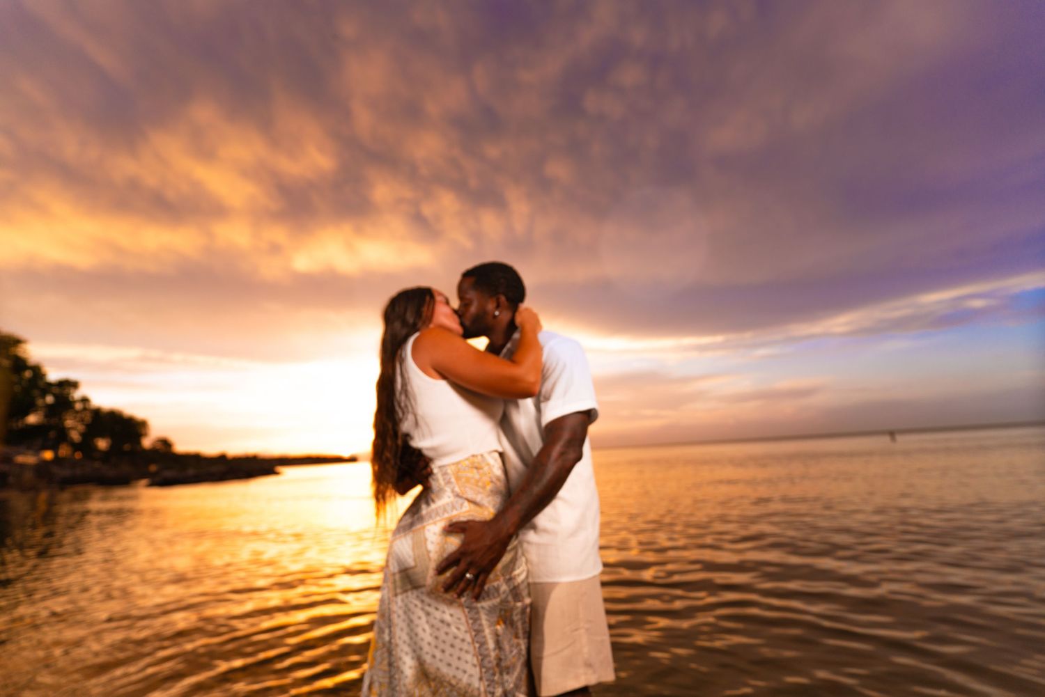 Beautiful sunset beach photography with dramatic purple and orange clouds reflecting on ocean water.