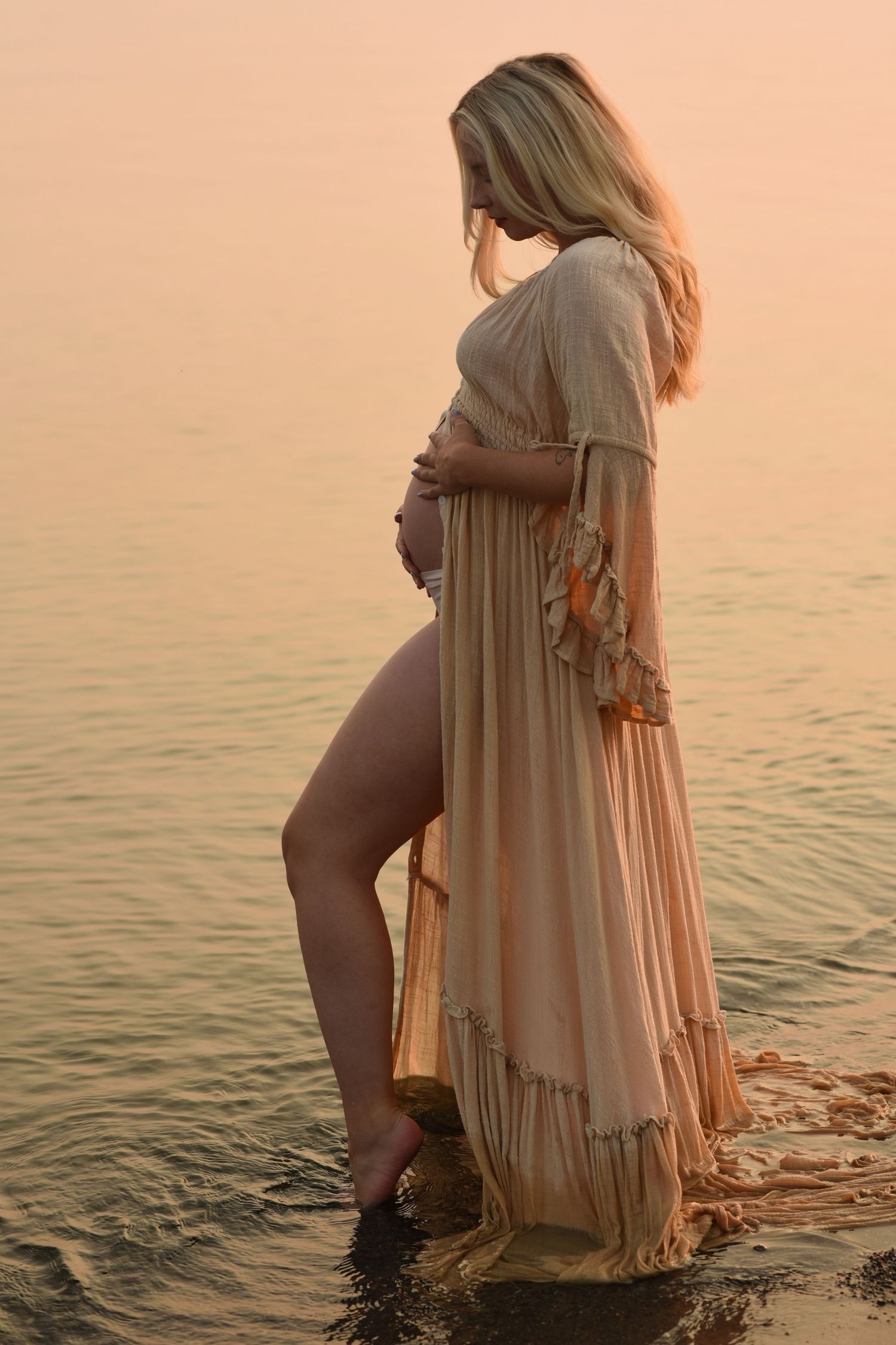 A serene maternity pose at the lake.