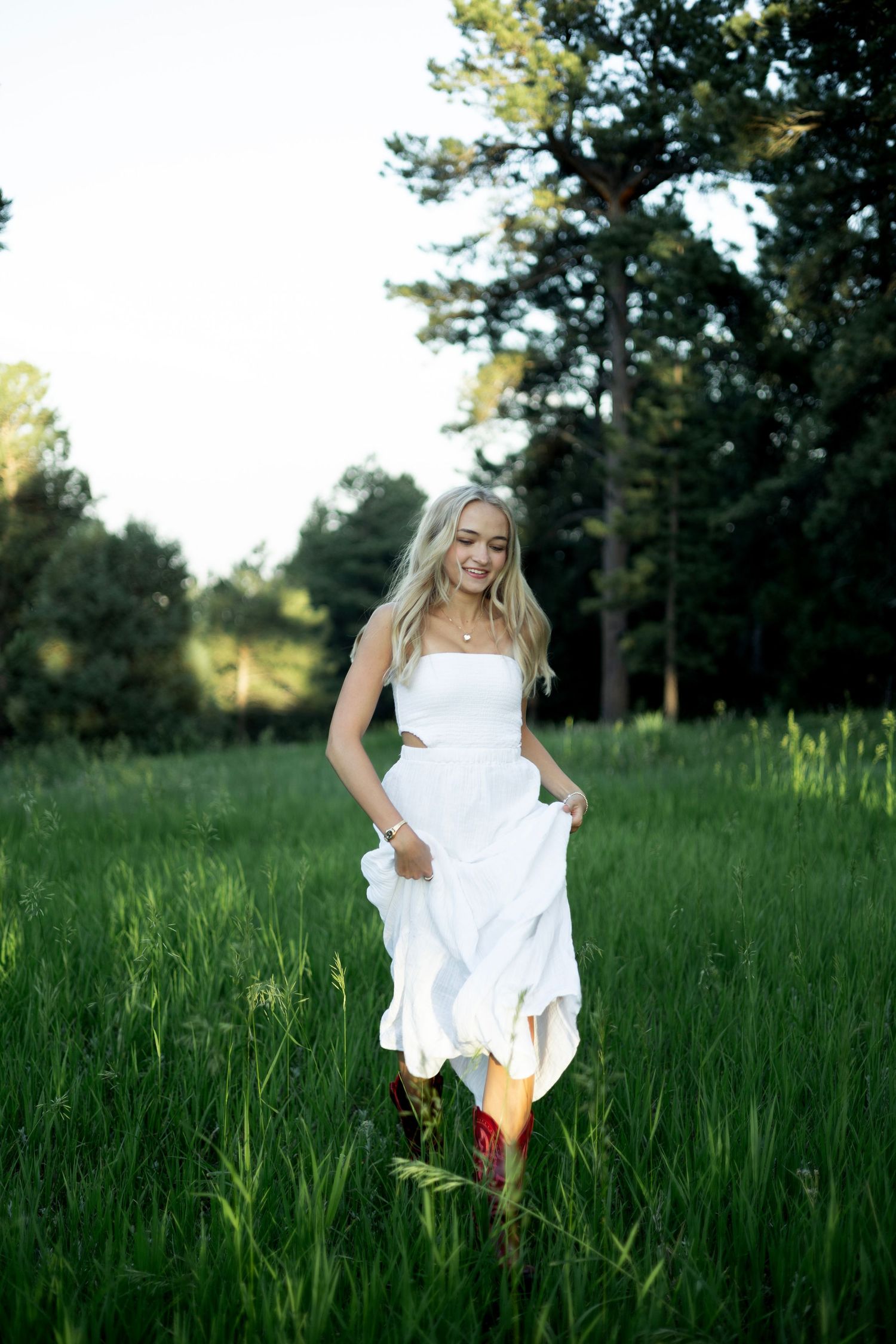 A serene photo series in a grassy meadow shows moments of carefree dancing in flowing white fabric.