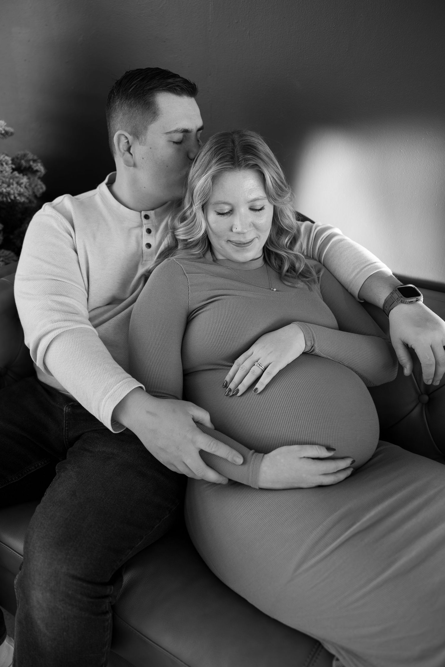 A black and white maternity photo series showing tender moments between an expectant couple during a pregnancy photoshoot.