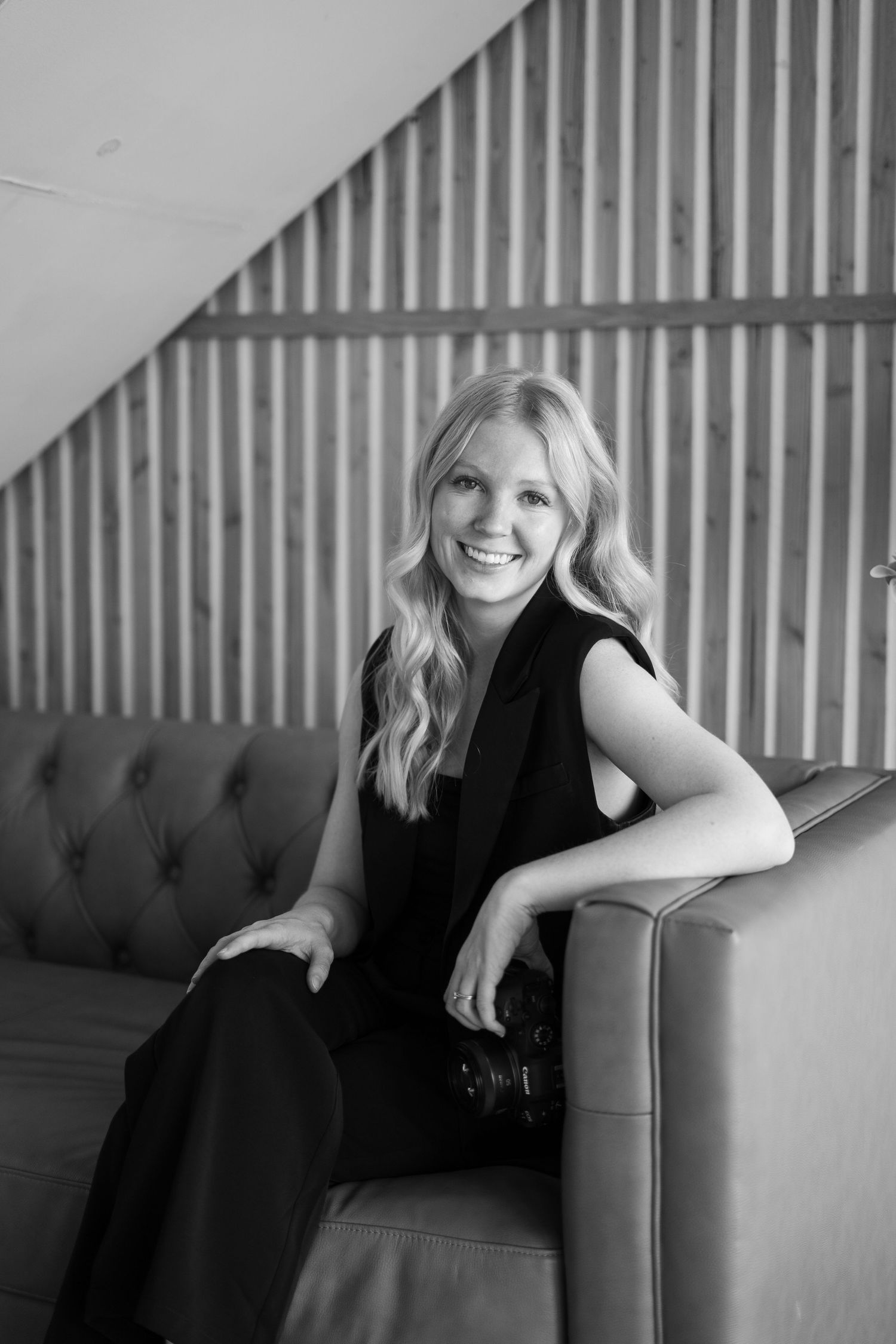 Black and white photo series showing a person in dark clothing lounging on a tufted couch against striped wall decor.