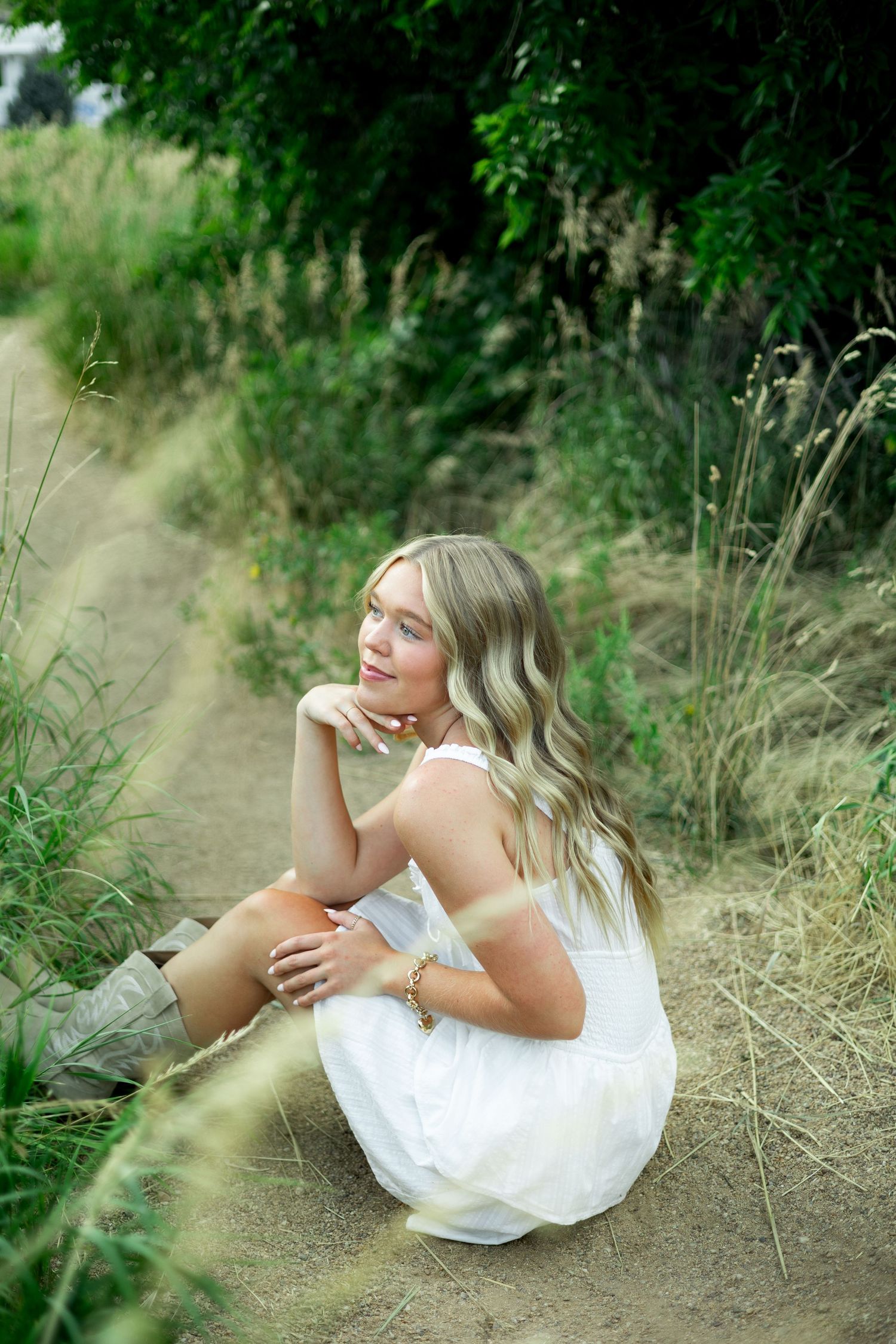 A dreamlike series of portraits showing someone in a white dress reclining in tall grass and wildflowers.