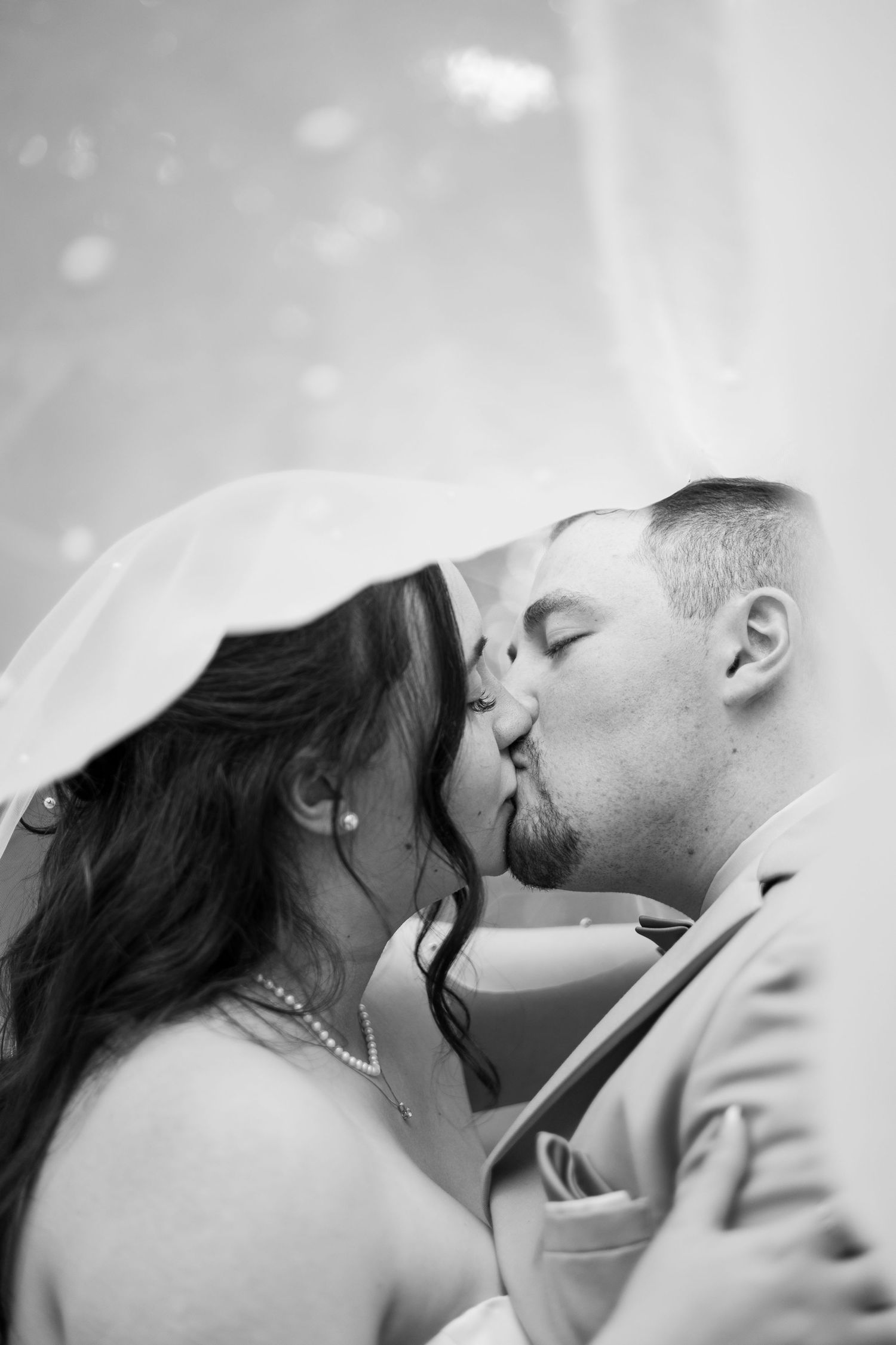 Black and white intimate wedding portrait showing a tender romantic moment.
