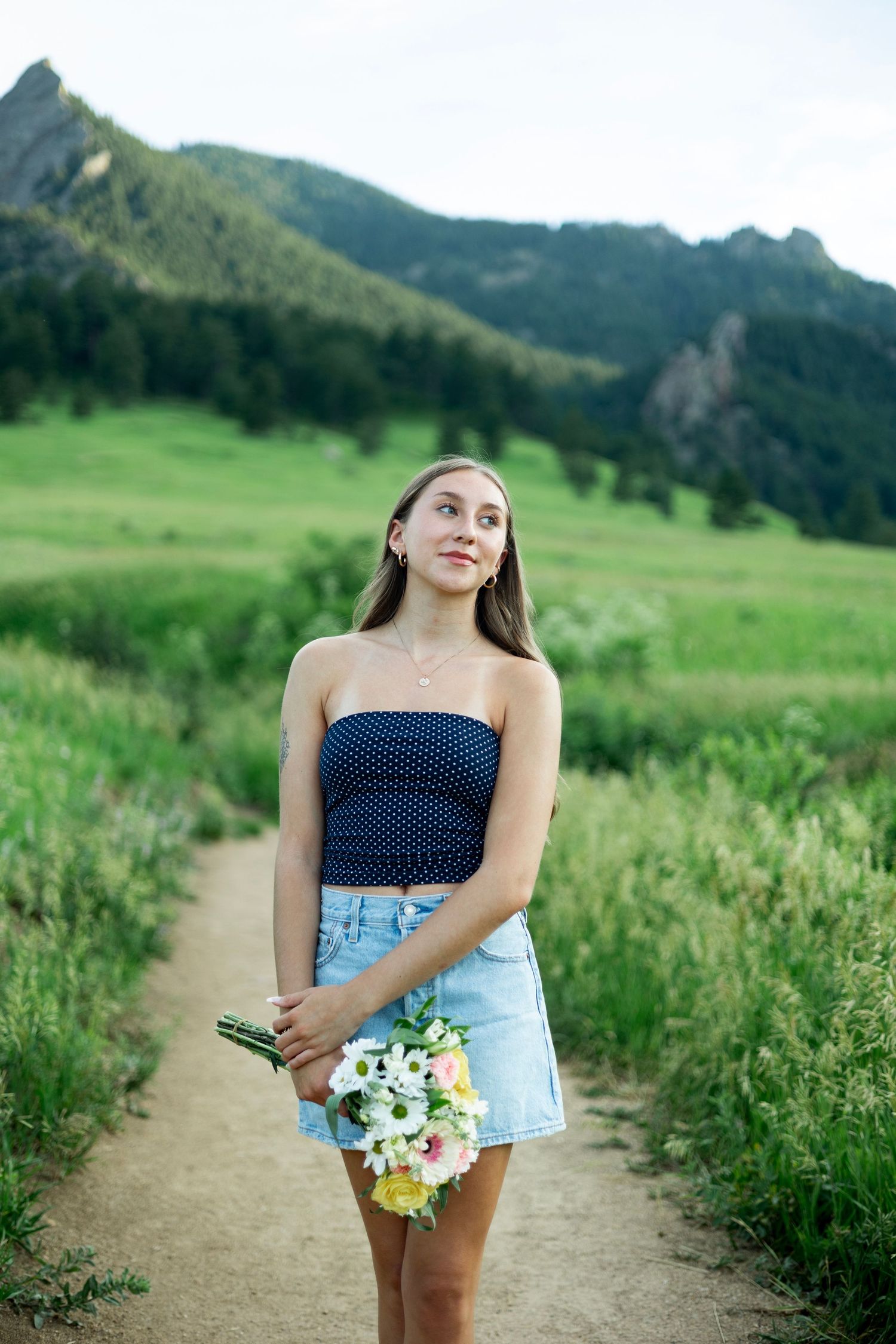 A scenic photo sequence showing someone in a polka dot top holding fresh flowers on a mountain trail during summer.