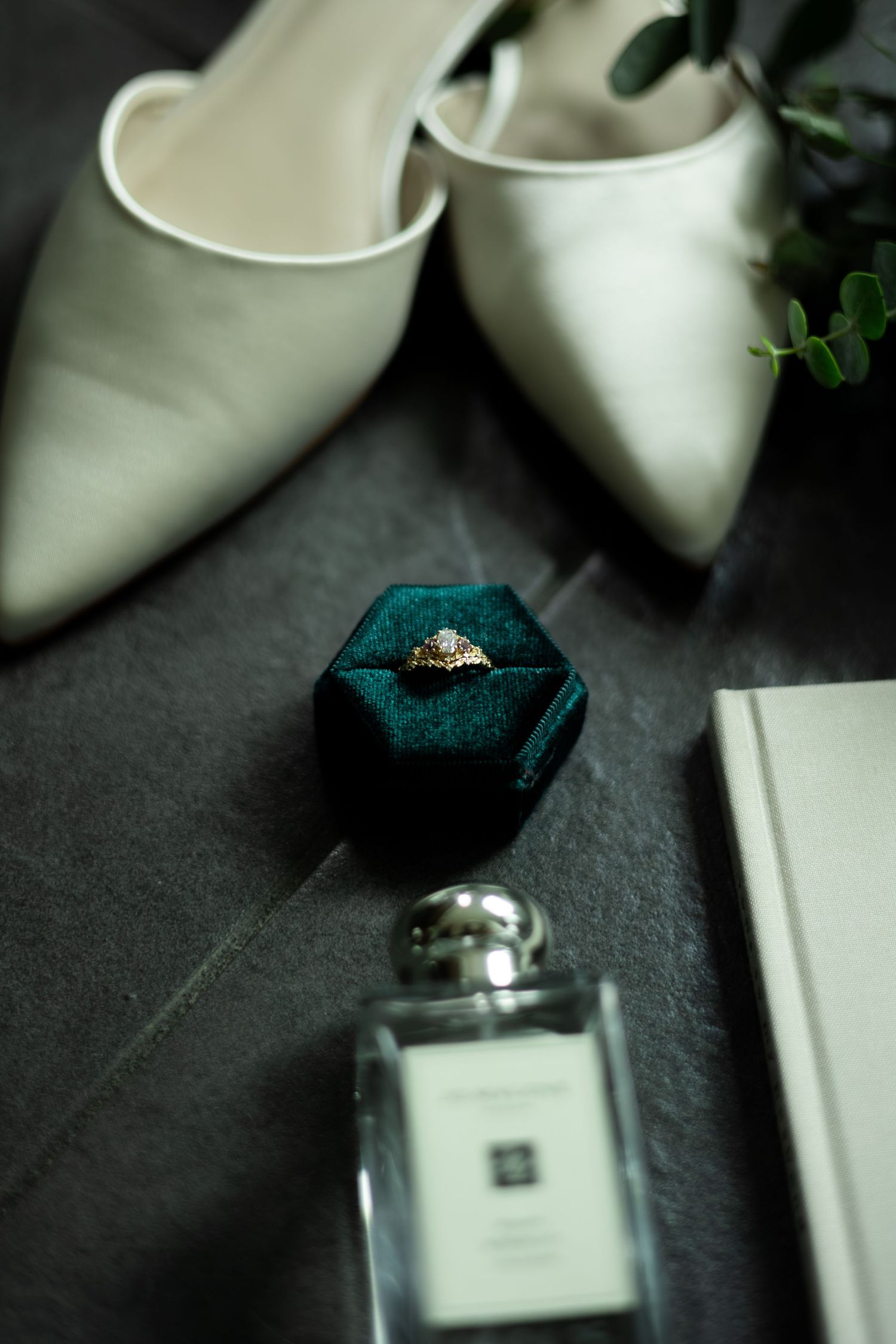 White bridal heels and teal socks arranged on dark background for wedding preparation detail shot.