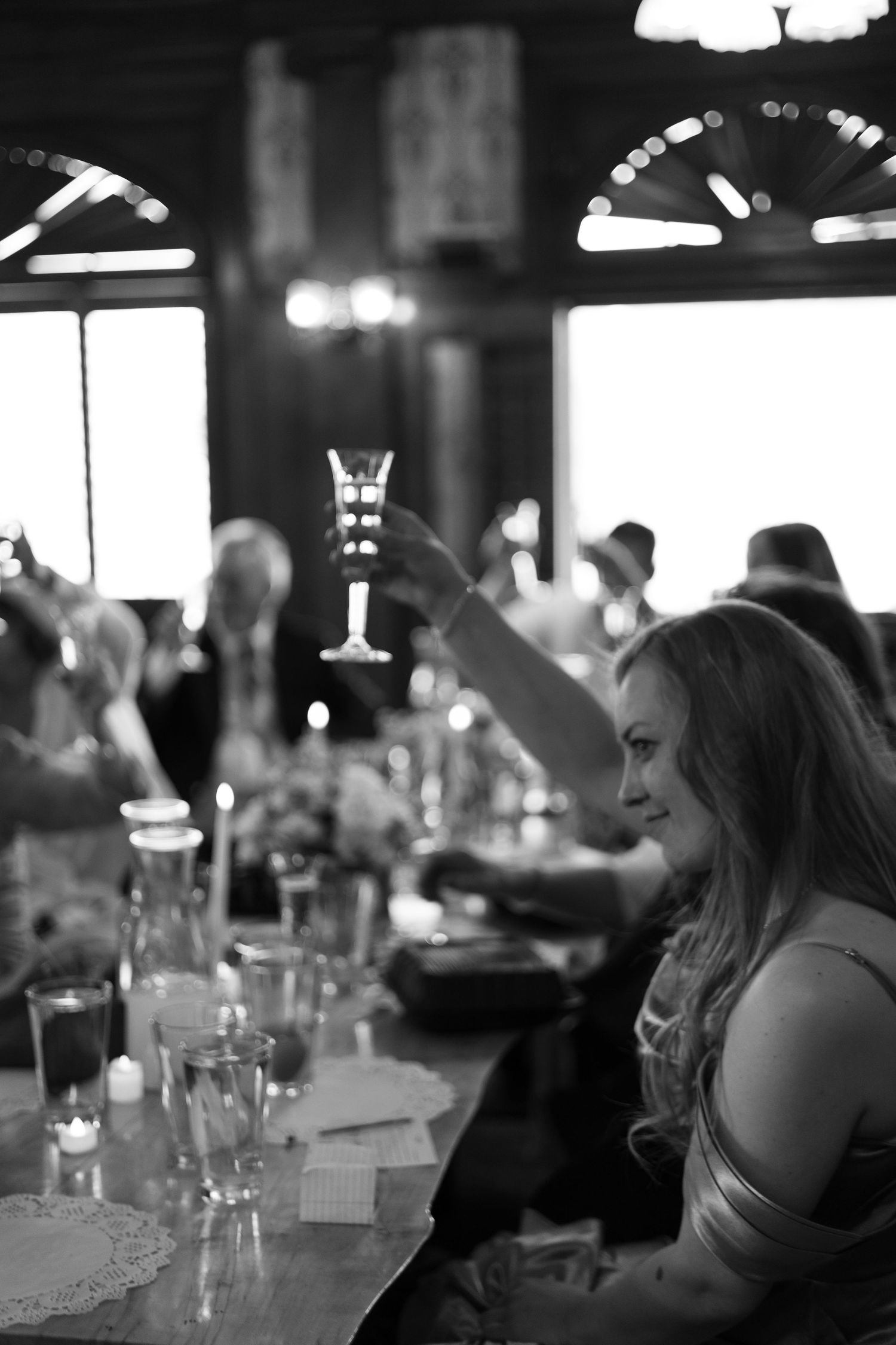 Atmospheric black and white shot of dining patrons sitting at a dimly lit restaurant table.