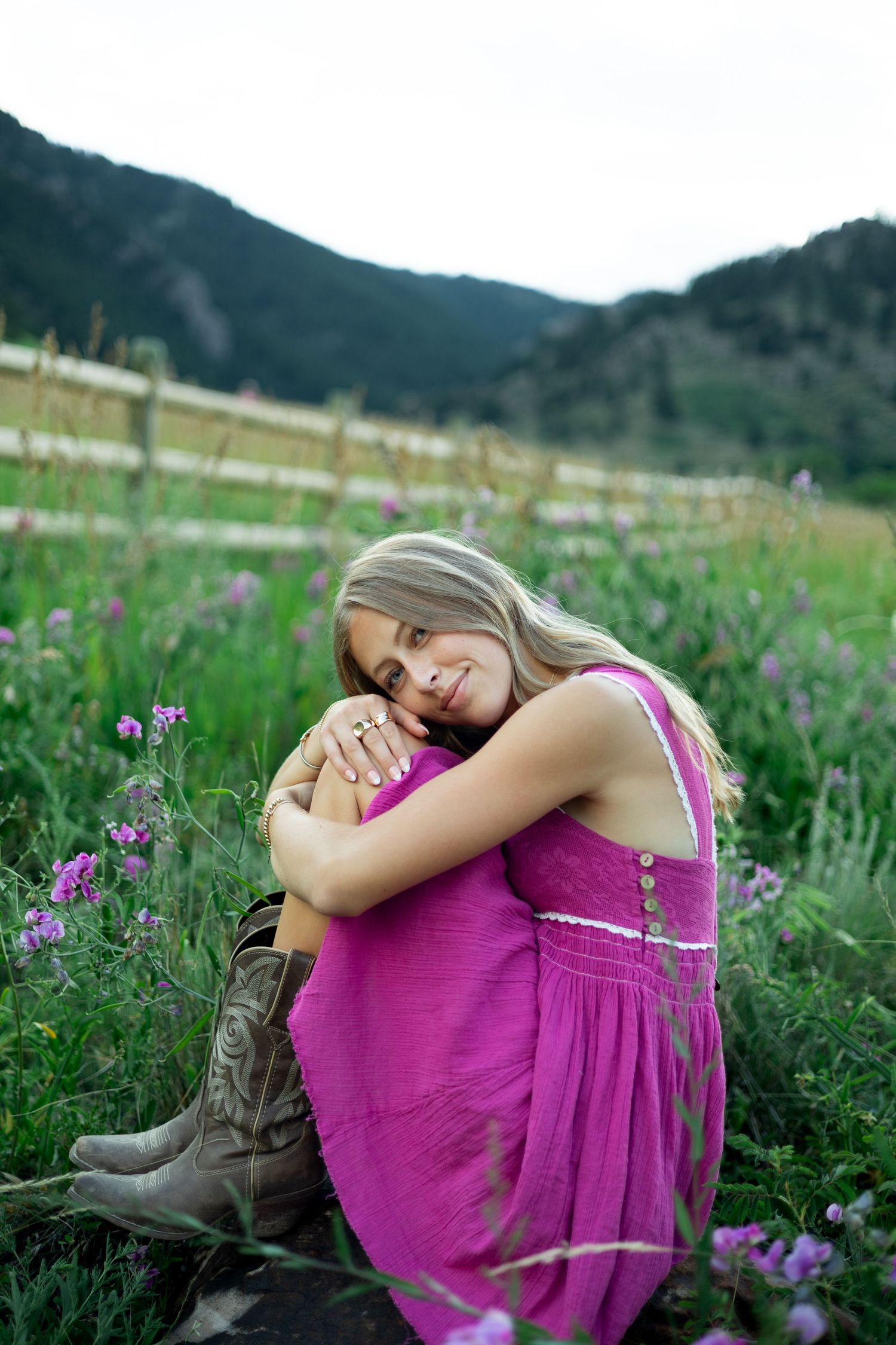 A relaxing moment captured in a field of purple flowers with mountain views and a magenta dress.